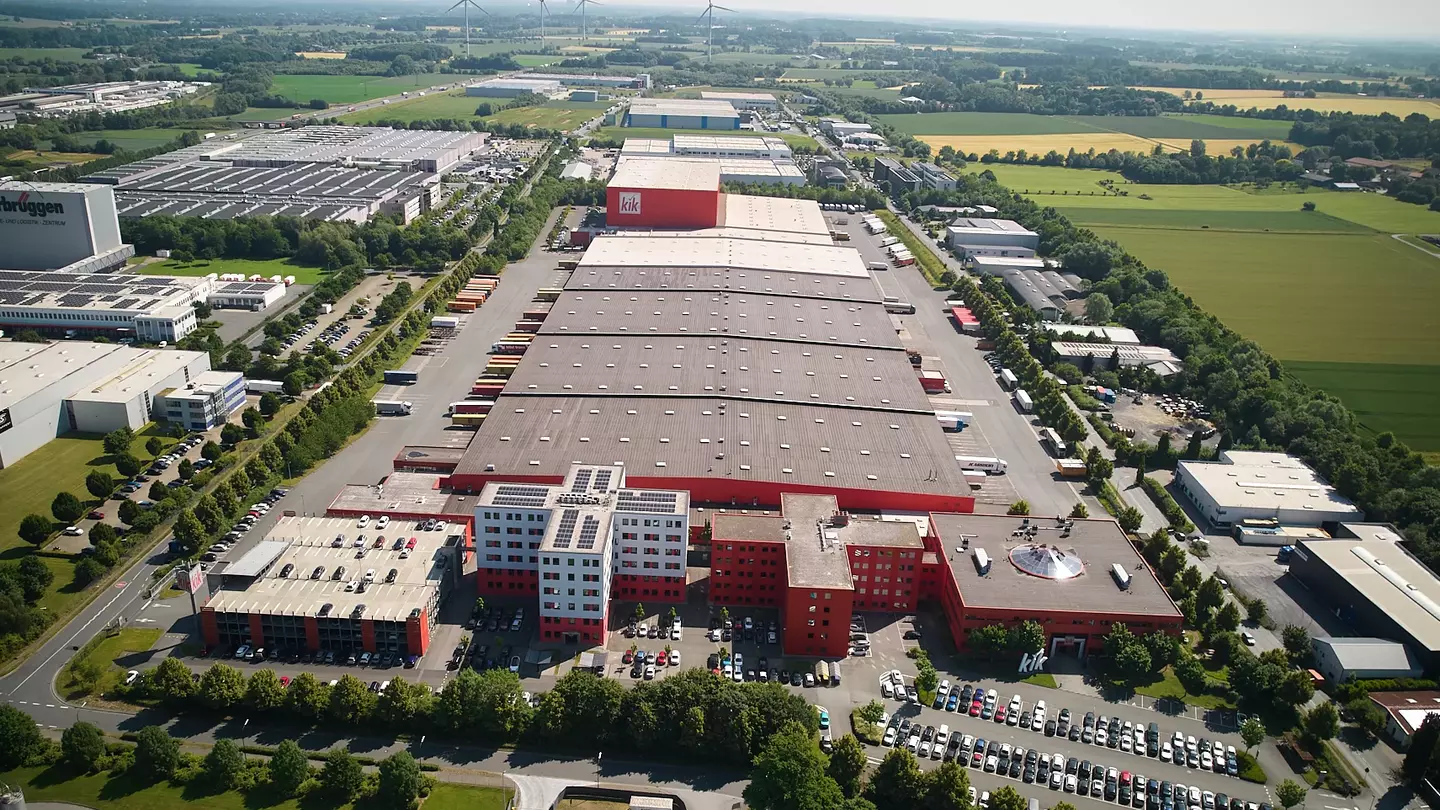 Luchtfoto van het Europese hoofdkantoor van KiK, bestaande uit drie kantorencomplexen met aangrenzende logistieke faciliteiten