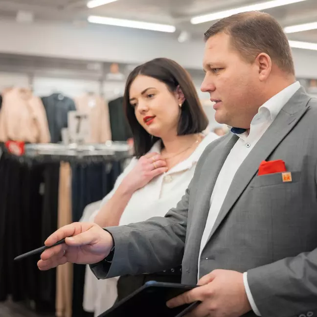 Twee medewerkers bekijken geconcentreerd het assortiment, met een tablet in de hand