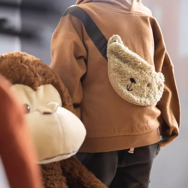 Kindertrui met een zak van fleece, als symbool voor de vele artikelen die in de KiK-webshop worden verkocht