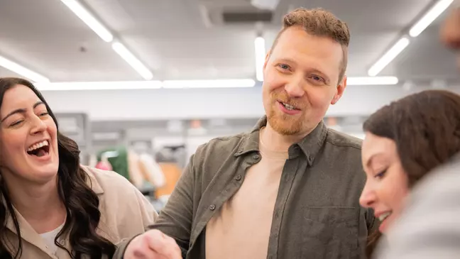 Medewerkers lachen samen tijdens een teamgesprek op de verkoopvloer