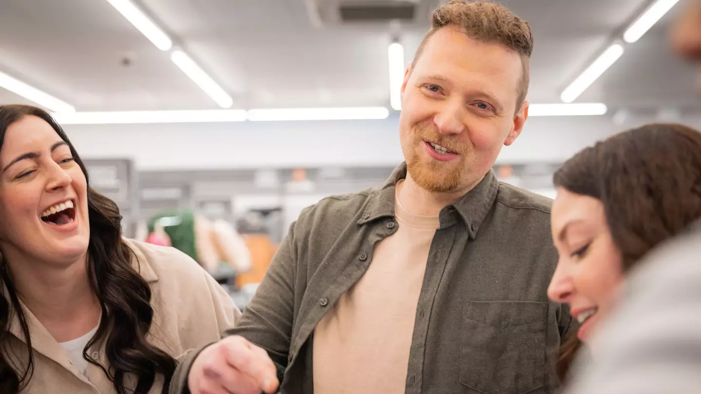 Medewerkers lachen samen tijdens een teamoverleg op de verkoopvloer.