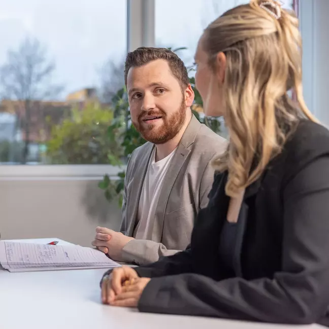Twee mensen zitten tijdens een sollicitatiegesprek in een modern kantoor